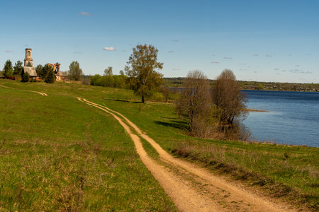 A scenic country road along the river leading to the temple. Beautiful rural landscape. Selected focus. High quality photoの写真素材