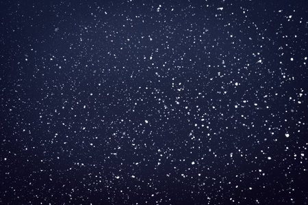 Natural snow particles in the air. Dark blue fading to black background. High quality photoの写真素材