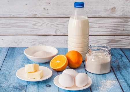 Crepe Suzette recipe. Ingredients on the table: milk, butter, sugar, eggs, flour, oranges. High...