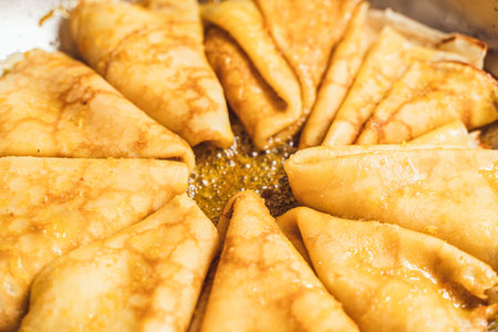 Close-up of crepe suzette laid out in a pan. Pancakes are soaked in sauce in a stainless steel frying pan. Selected focus. High quality photoの写真素材