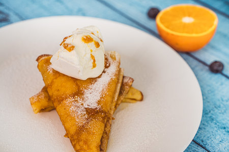 Close-up of pancakes on a white plate with ice cream and orange sauce. Crepe suzette for menu placement. High quality photoの写真素材