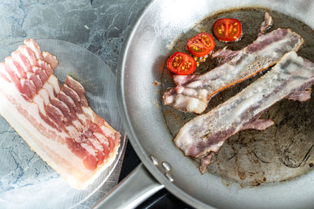 Strips of bacon are fried in a pan. High quality photoの写真素材