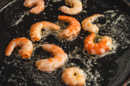 Close-up of shrimp fried in oil in a cast iron skillet, Cooking delicious king prawns. Selected focus. High quality photoの写真素材