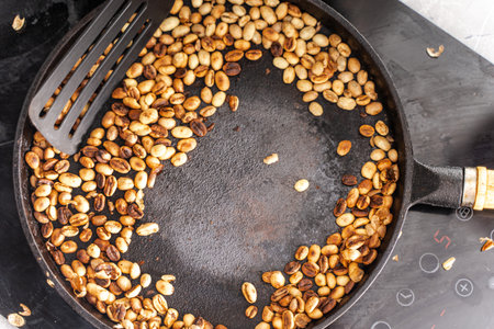 Medium roast coffee beans smoking in a frying pan. Copy space. Selected focus. High quality photoの写真素材