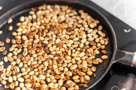Medium roasted coffee beans are smoky in a roasting pan. Selected focus. High quality photoの写真素材