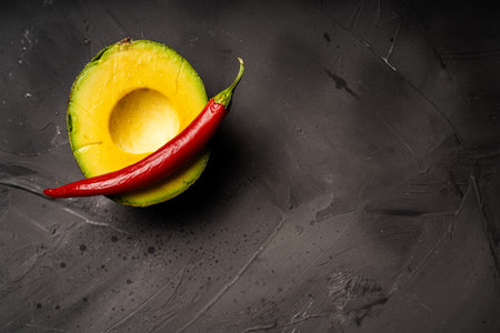 Avocado and red hot pepper on a black background. High quality photoの写真素材