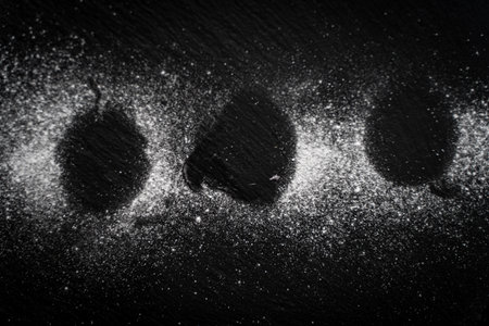 White powdered sugar is poured on a black mica board. Background. A cake board. High quality photoの写真素材