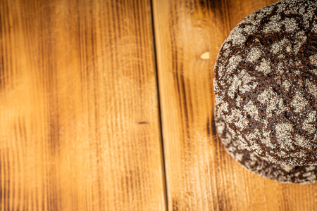Round wheat bread and small rye bread rolls on a wooden background. Space for text. High quality...