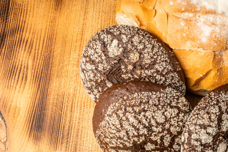 Round wheat bread and small rye bread rolls on a wooden background. Space for text. High quality photoの写真素材