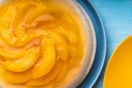 Peach, jelly dessert or cake. Homemade cheesecake with canned peaches on a blue plate. High quality...