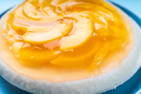 Peach, jelly dessert or cake. Homemade cheesecake with canned peaches on a blue plate. High quality photoの写真素材
