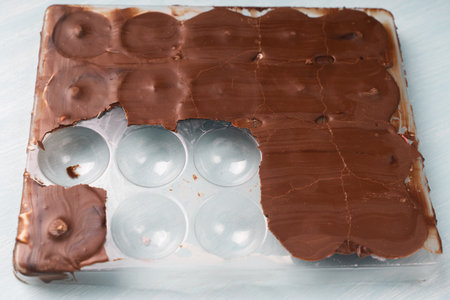 The mold for making chocolate candies is filled with solidified chocolate and finished candies in pink glaze. Homemade chocolate recipe. High quality photoの写真素材