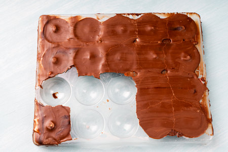 The mold for making chocolate candies is filled with solidified chocolate and finished candies in pink glaze. Homemade chocolate recipe. High quality photoの写真素材