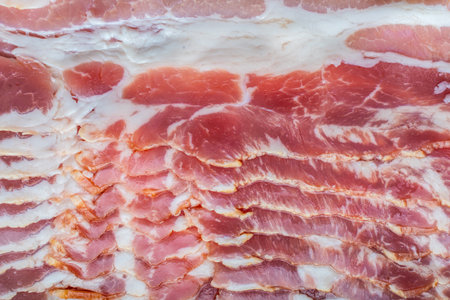 Background with raw bacon texture. Thin slices of raw bacon close-up. High quality photoの写真素材