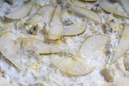 Pizza textured background with pear and gorgonzola and parmesan cheese. Raw pizza in a curly plan. High quality photoの写真素材