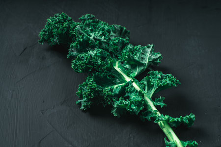 Green leaf of cabbage or kale lettuce on a dark background, close-up top view with copy space. Healthy vegetables for detoxification. Clean eating and diet concept. Health benefits of cabbage. High quality photoの写真素材