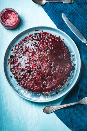 Cherry chocolate clafutis on a light blue plate. French pie according to a traditional recipe. A quick homemade dessert. Vertical photo. High quality photoの写真素材