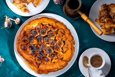 Traditional homemade banana caramel pie. French Tarte Tatin on a white plate with Turkish coffee on a green, emerald background. High quality photoの写真素材