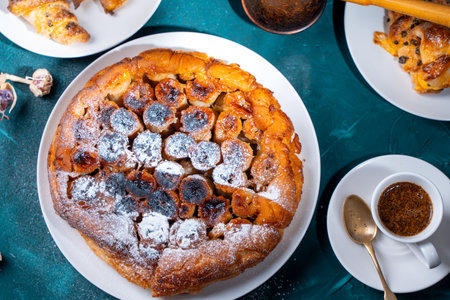 Traditional homemade banana caramel pie. French Tarte Tatin on a white plate with Turkish coffee on a green, emerald background. Top view. High quality photoの写真素材