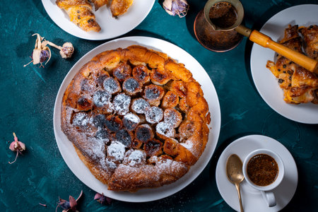 Traditional homemade banana caramel pie. French Tarte Tatin on a white plate with Turkish coffee on a green, emerald background. Top view. High quality photoの写真素材