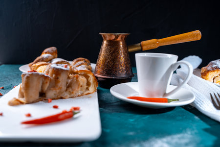A slice of banana pie with hot chili peppers and coffee cooked in a cezve on a dark green background. French Tarte Tatin and handmade croissants on the table. High quality photoの写真素材