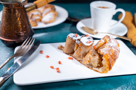 Banana dessert Tarte tatin and croissants on a dark green background with a cup of coffee brewed in a cezve and freeze-dried raspberries. High quality photoの写真素材
