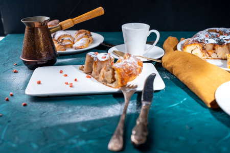 Banana dessert Tarte tatin and croissants on a dark green background with a cup of coffee brewed in a cezve and freeze-dried raspberries. High quality photoの写真素材