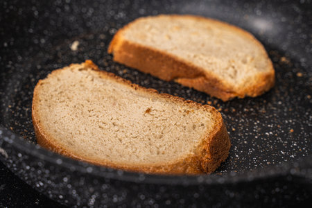 Bread toast is toasted in a black pan. High quality photoの写真素材