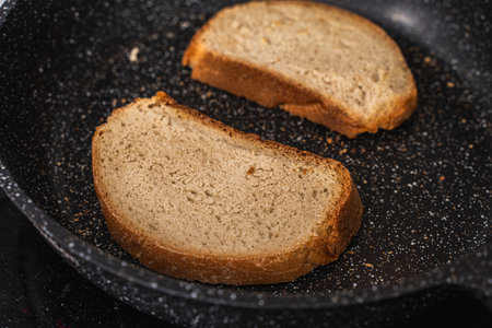 Bread toast is toasted in a black pan. High quality photoの写真素材