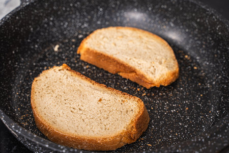 Bread toast is toasted in a black pan. High quality photoの写真素材