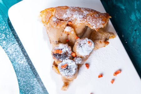 A slice of banana pie or tart on a white plate on a turquoise background. Close-up. High quality photoの写真素材