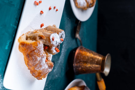 A piece of banana cake or pie and a cup of Turkish coffee on a white plate on a turquoise...