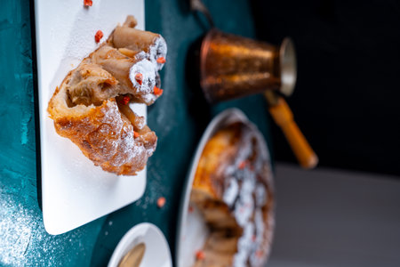 A piece of banana cake or pie and a cup of coffee on a white plate on a turquoise background. Dessert on the table. Vertical photo. High quality photoの写真素材