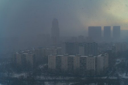 A snowstorm covers the big city, a gloomy sky with glimpses of the sun. Aerial shooting. Space for text. High quality photoの写真素材