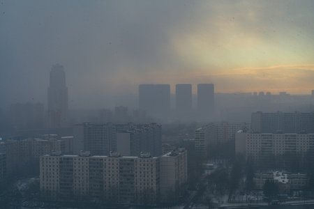 A snowstorm covers the big city, a gloomy sky with glimpses of the sun. Aerial shooting. Space for text. High quality photoの写真素材