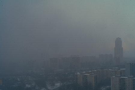 A snowstorm covers the big city, a gloomy sky with glimpses of the sun. Aerial shooting. Space for text. High quality photoの写真素材
