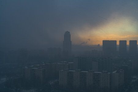 A snowstorm covers the big city, a gloomy sky with glimpses of the sun. Aerial shooting. Space for text. High quality photoの写真素材