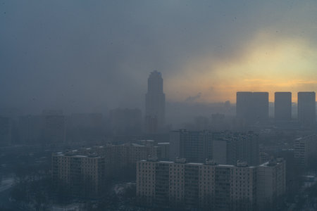 A snowstorm covers the big city, a gloomy sky with glimpses of the sun. Aerial shooting. Space for text. High quality photoの写真素材