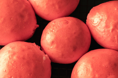 Freshly baked pink burger buns on a black grill. View from above. Close-up. High quality photoの写真素材