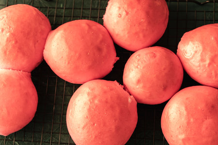 Freshly baked pink burger buns on a black grill. View from above. Close-up. High quality photoの写真素材