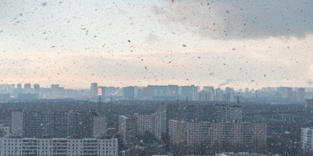 Panorama of a big city, it is snowing, cloudy and clear sky with snowflakes, aerial view of residential high-rise buildings. High quality photoの写真素材