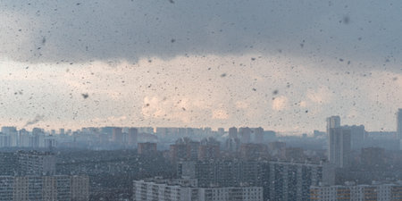 Panorama of a big city, it is snowing, cloudy and clear sky with snowflakes, aerial view of residential high-rise buildings. High quality photoの写真素材