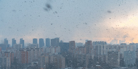 Panorama of a big city, it is snowing, cloudy and clear sky with snowflakes, aerial view of residential high-rise buildings. High quality photoの写真素材