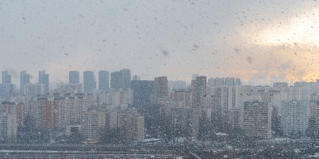 Panorama of a big city, it is snowing, cloudy and clear sky with snowflakes, aerial view of residential high-rise buildings. High quality photoの写真素材