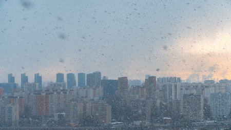 Panorama of a big city, it is snowing, cloudy and clear sky with snowflakes, aerial view of residential high-rise buildings. High quality photoの写真素材