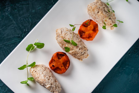 Chicken meatballs and mini carrot waffles with microgreens on a white rectangular plate on a dark green background. Top view. Beautiful presentation. Close-up. Place for text. High quality photoの写真素材