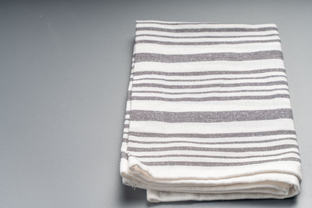 The towel is light gray with white stripes on a gray background. Space for text. High quality photo