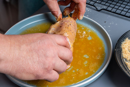 The cook's hands envelop the chicken breast in breadcrumbs. The process of preparing Corden Blue according to a traditional French recipe,. High quality photoの写真素材