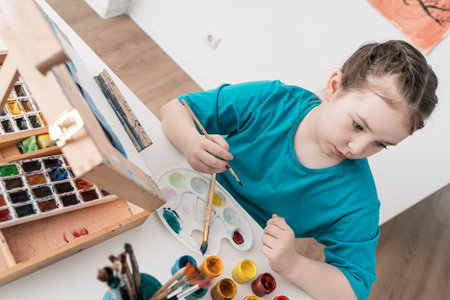Cute little girl mixing paints on palette. Selected Focus. High quality photoの写真素材