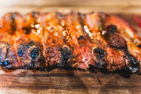 Top view of delicious grilled pork ribs with ketchup and mustard served on a wooden board. A dish for beer. Selected Focus. High quality photoの写真素材